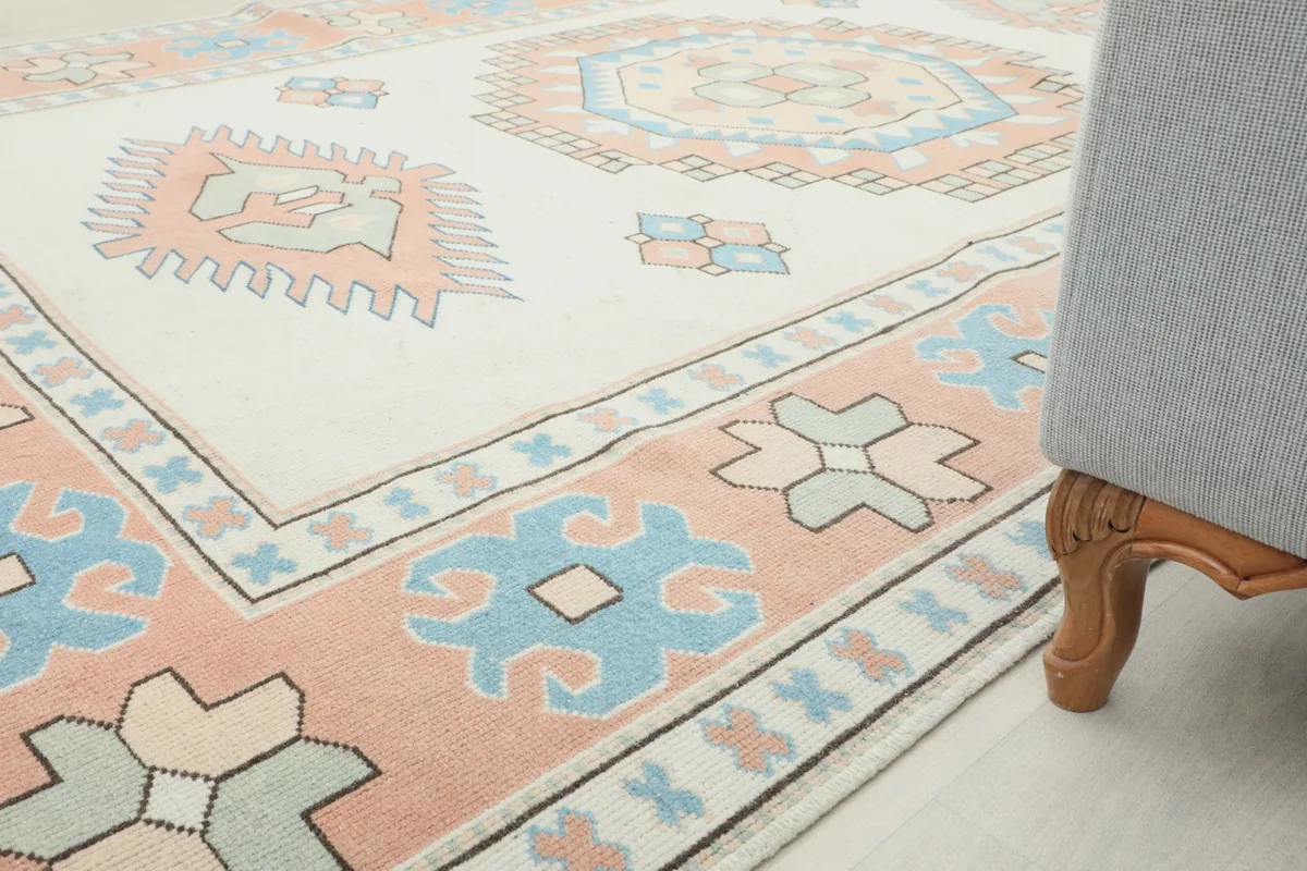 Close-up perspective of the rug next to a chair, illustrating the blend of colors and patterns with room elements.