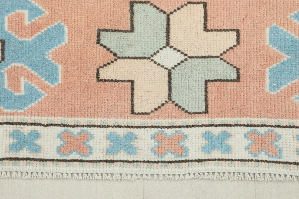 Close-up detail of the rose border with light blue and cream geometric motifs.