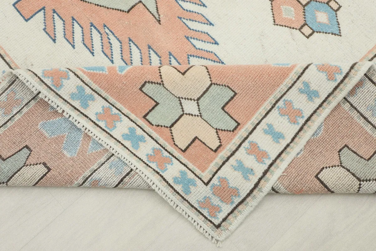 Folded corner of the rug, revealing the thickness and texture of the hand-knotted wool pile.