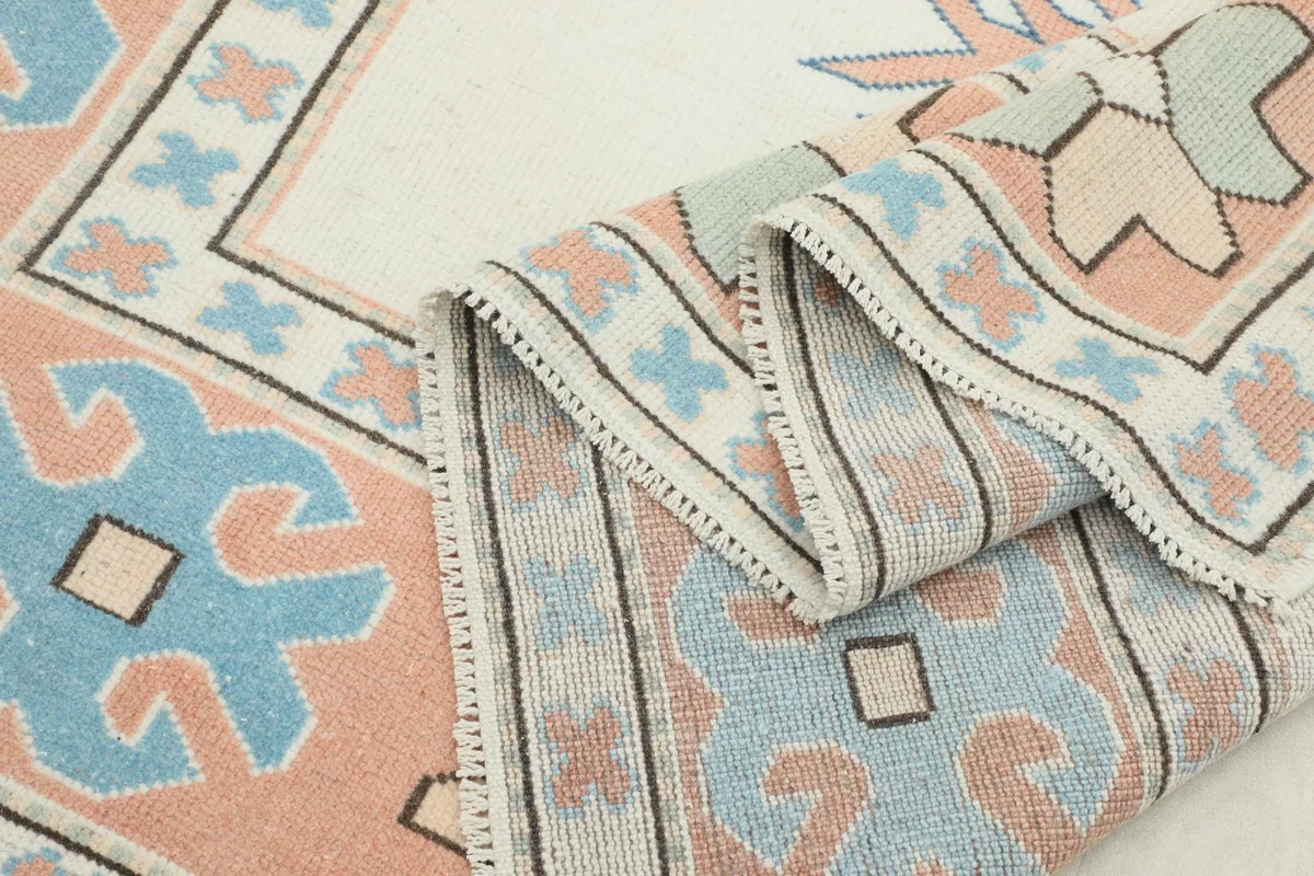 View of the rug folded, showcasing the reverse side and the construction of the vintage piece.