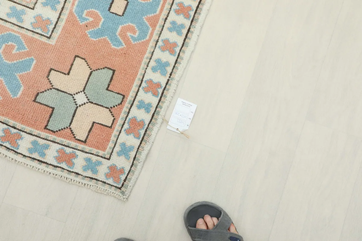 Overhead shot showing a foot next to the rug, indicating scale and the low pile texture.