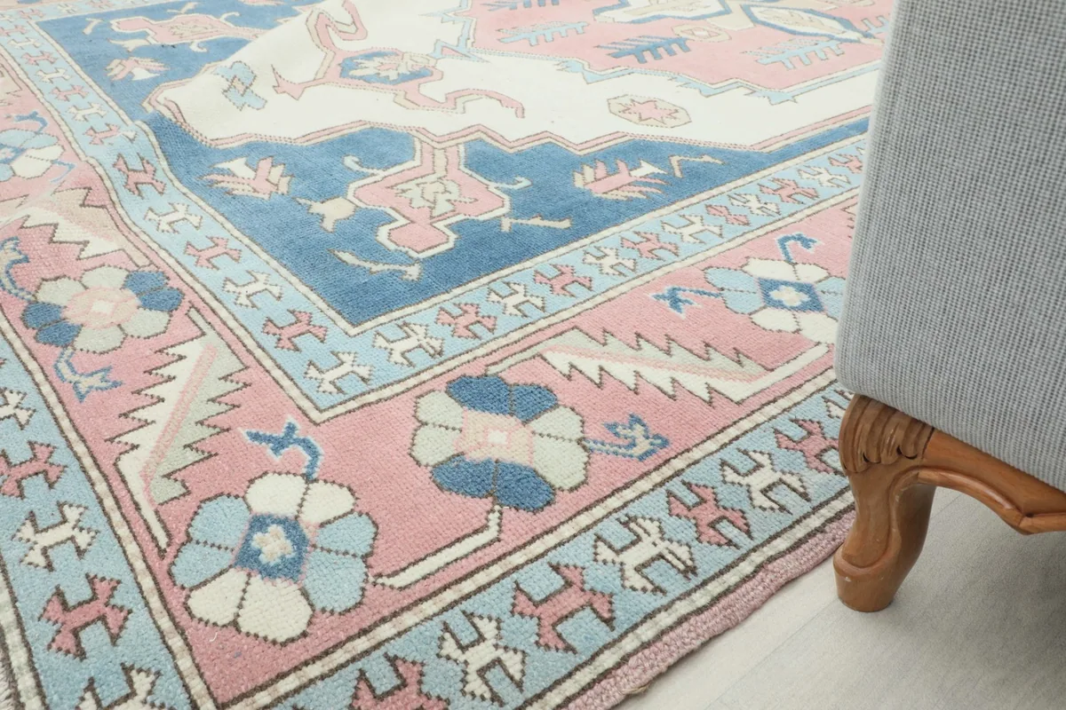 Low angle view of the rug's border and field, with a furniture leg visible on the right