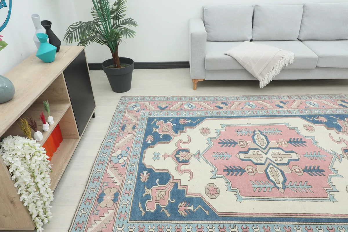 Angle view of the rug in a room, highlighting the full pattern and colors next to furniture