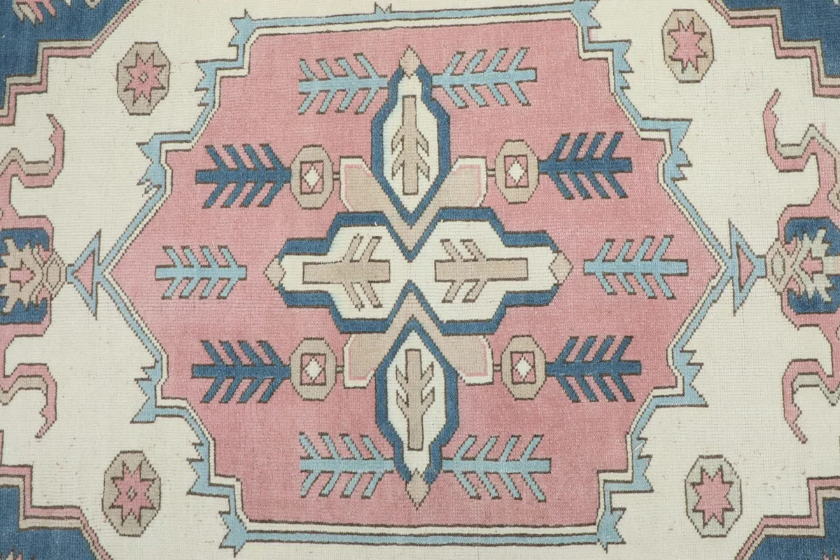 Detailed view of the central medallion with rose, navy, ivory, and tan geometric motifs