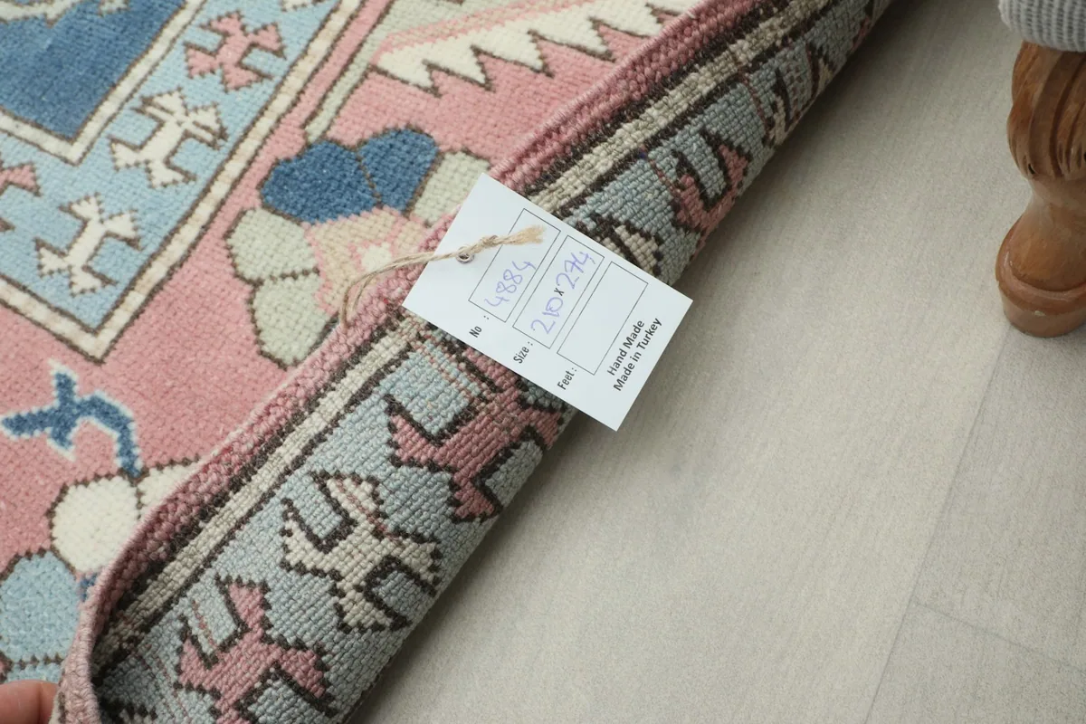 View of the rug's reverse side and edge, with a product tag attached