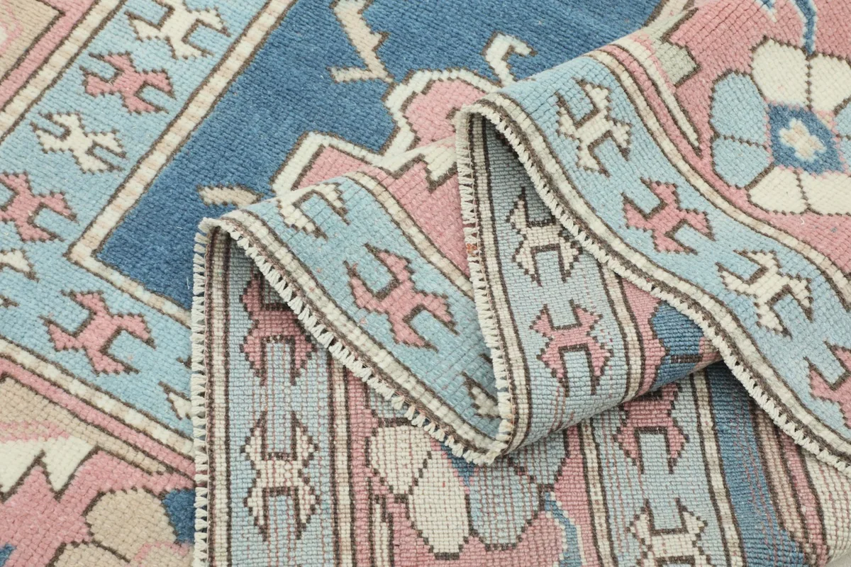Multiple folds of the rug showing the texture and detail of the hand-knotted wool pile