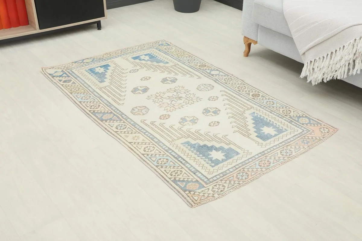 Angle view of the ivory and blue geometric rug placed in a light-filled room