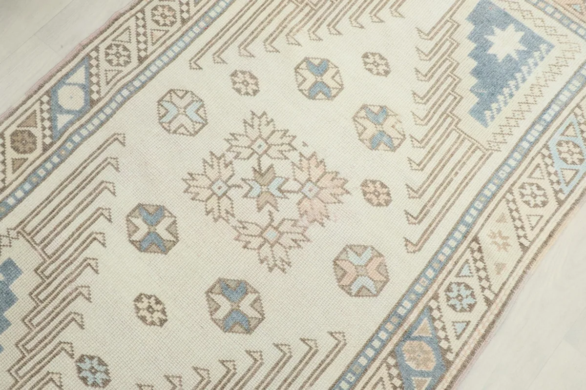 Mid-section detail of the ivory rug, highlighting the central tribal and geometric designs