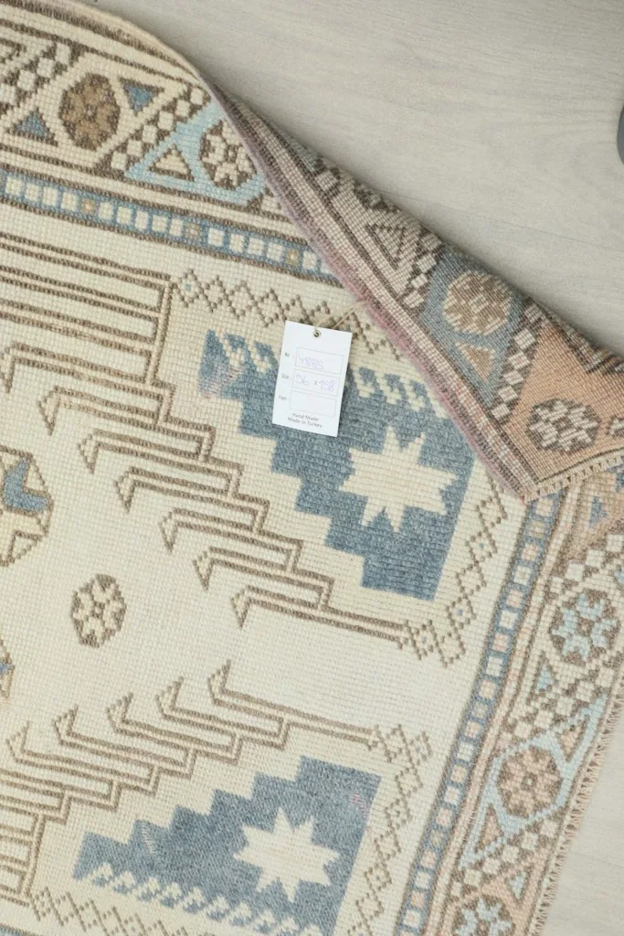 Close-up of the rug's back, revealing the hand-knotted construction and care tag