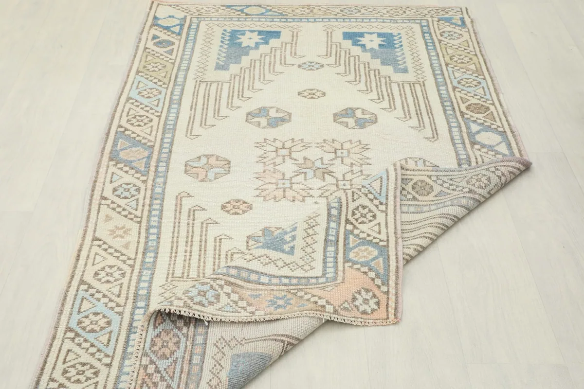 Rug partially folded, displaying the back of the rug and the reverse side of the patterns