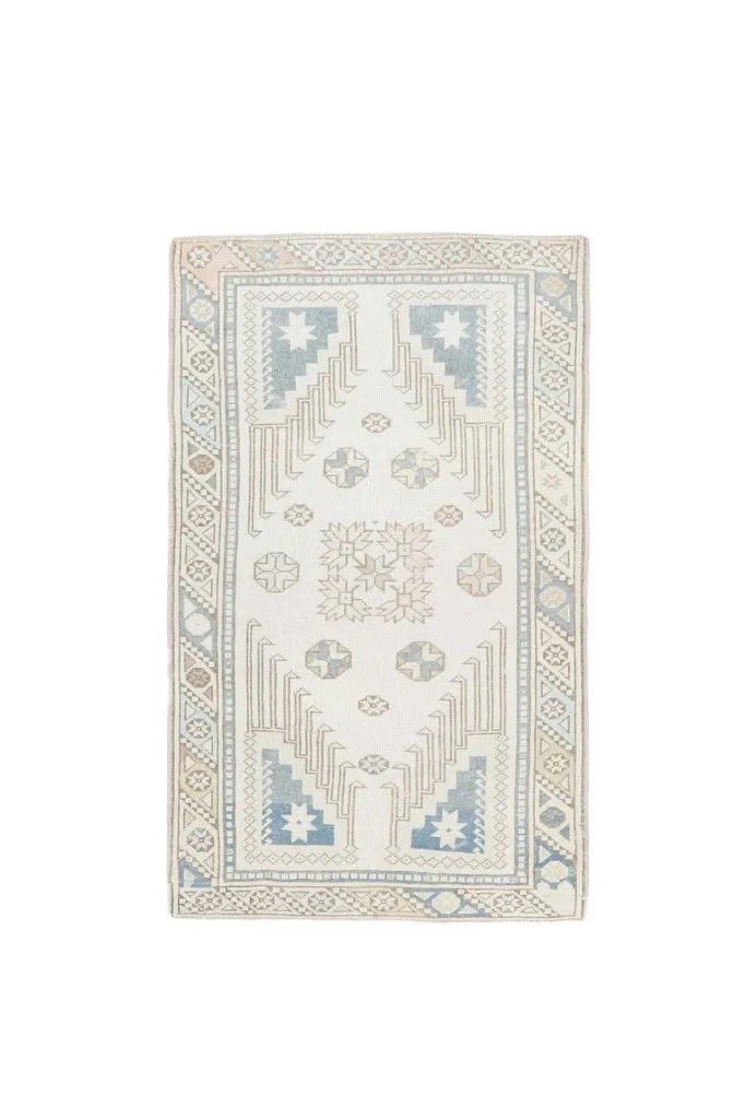 Full overhead shot of the ivory and blue vintage Anatolian rug on a white background