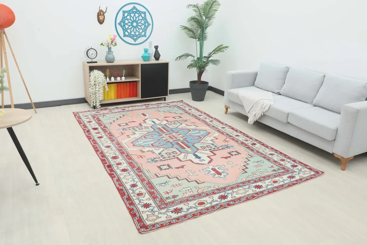 Vintage Anatolian rug in a modern living room setting with a gray sofa and wooden console.