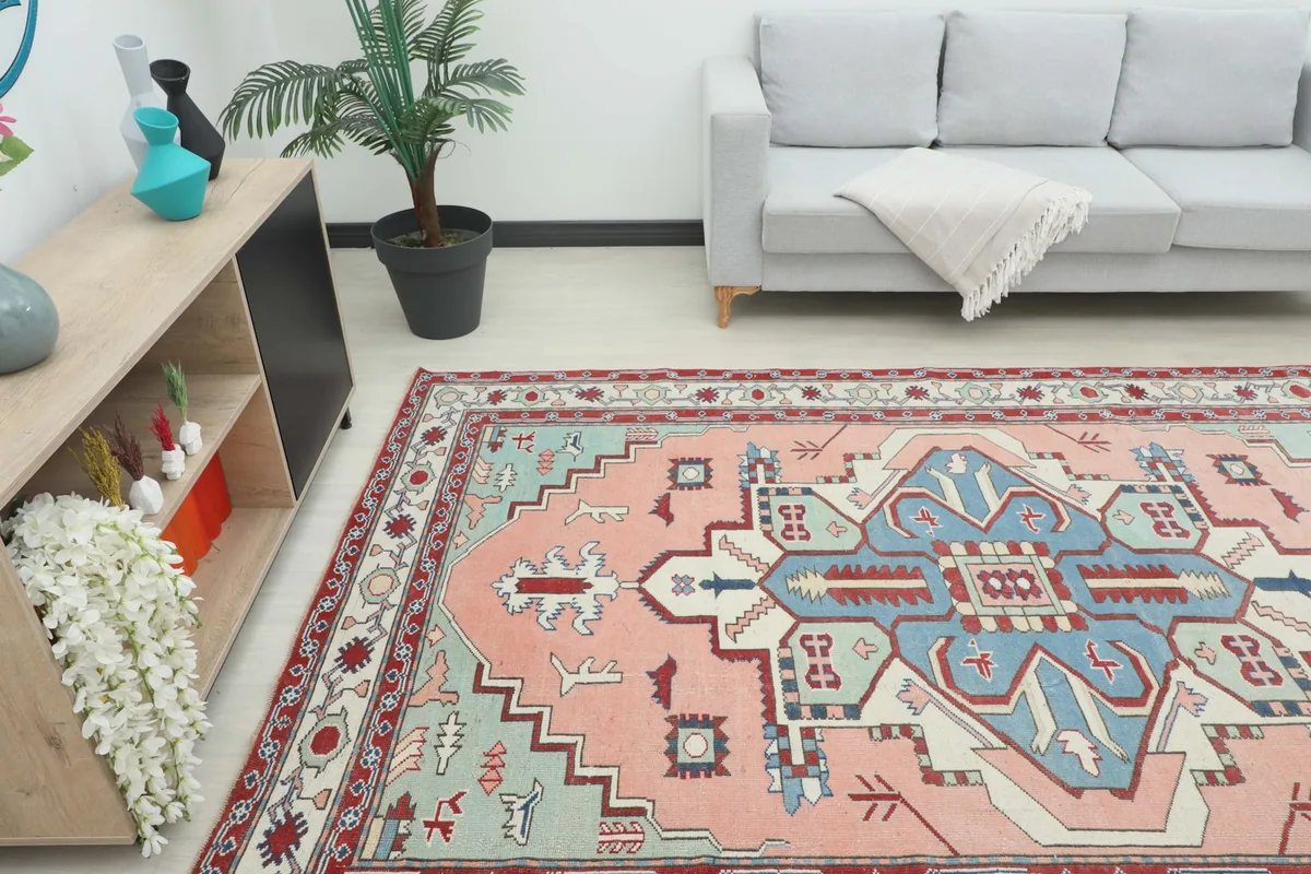 Angle view of the pink and blue vintage rug in a living space, showing its size in context.