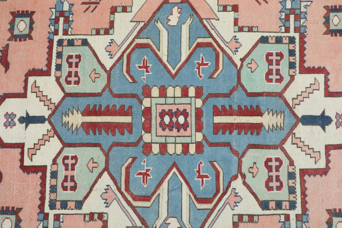 Detailed view of the central blue geometric medallion and surrounding pink field.