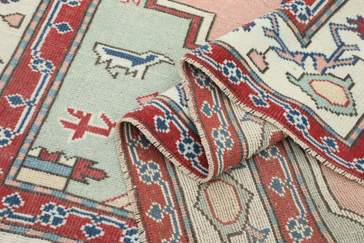 Rolled section of the rug, displaying the side and detailed geometric patterns.