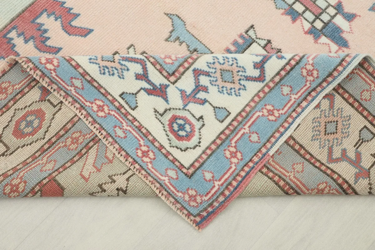 Rug corner folded to reveal the reverse side and the hand-knotted wool pile and cotton foundation.