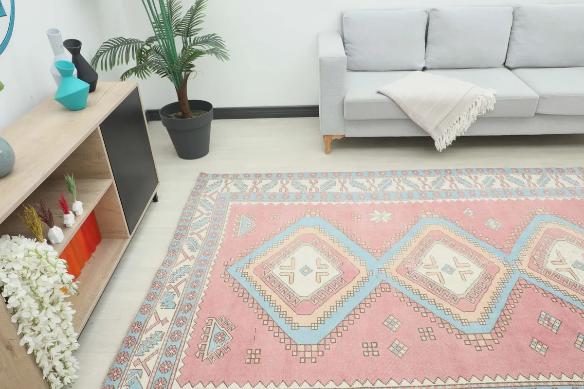Angled view of the rose tribal diamond rug in a living room, highlighting its placement and colors
