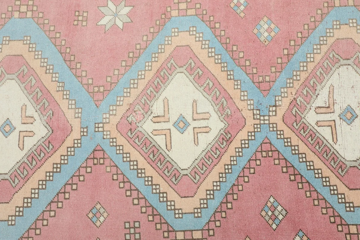 Detailed view of the central rose field with stacked blue, ivory, and orange geometric diamond motifs