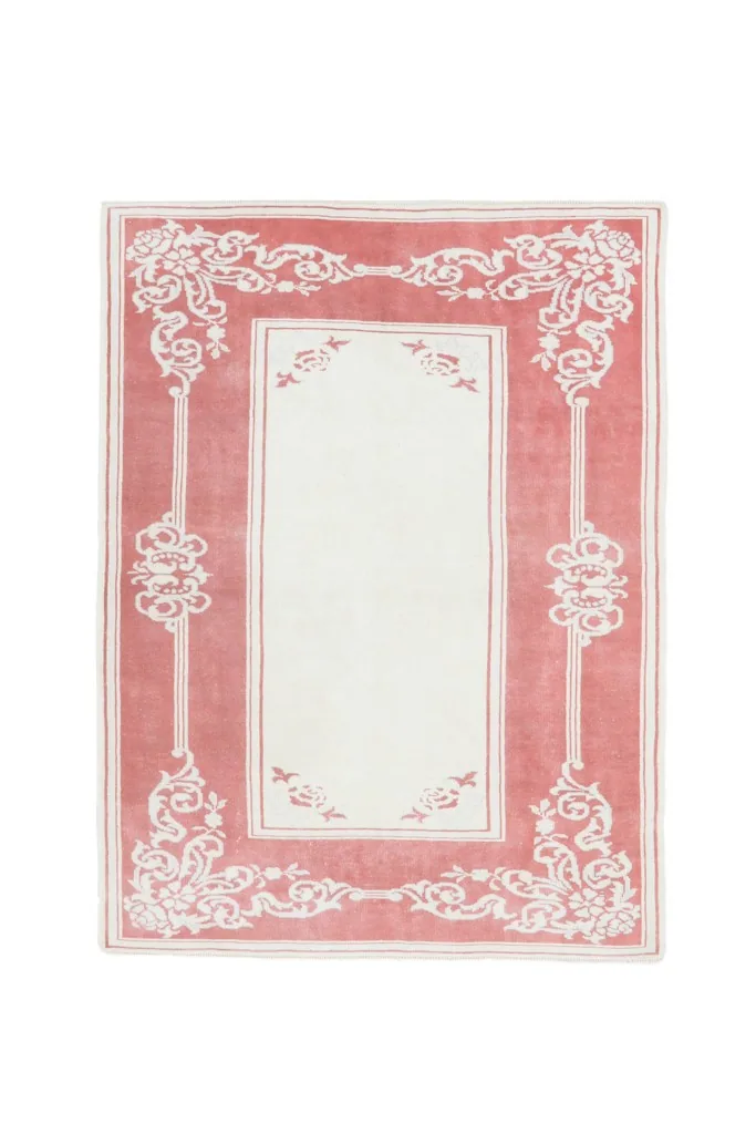 Full view of the rug from above, showcasing its balanced rose and ivory design