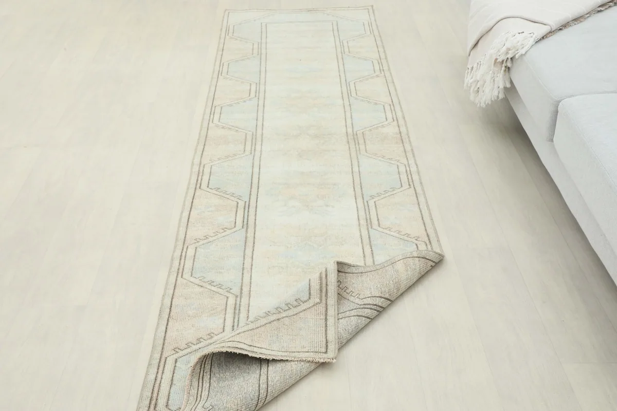 Overhead view of the rug with one end partially folded, showcasing its length and design