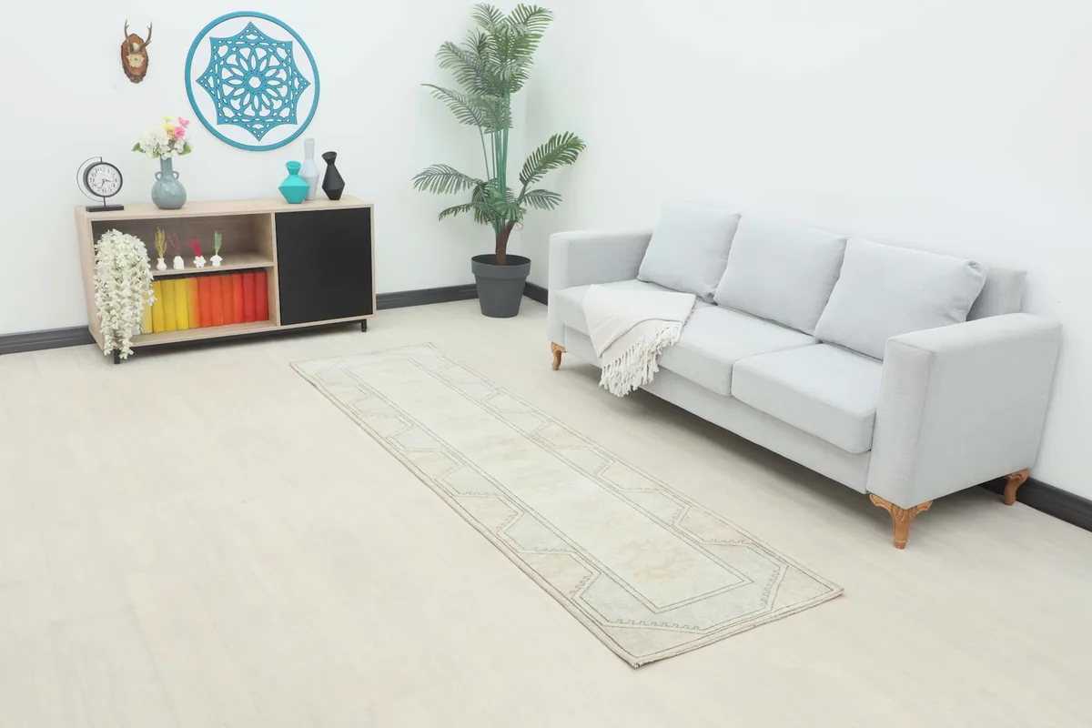 Vintage runner rug in an entryway or living space, next to a gray sofa and console table