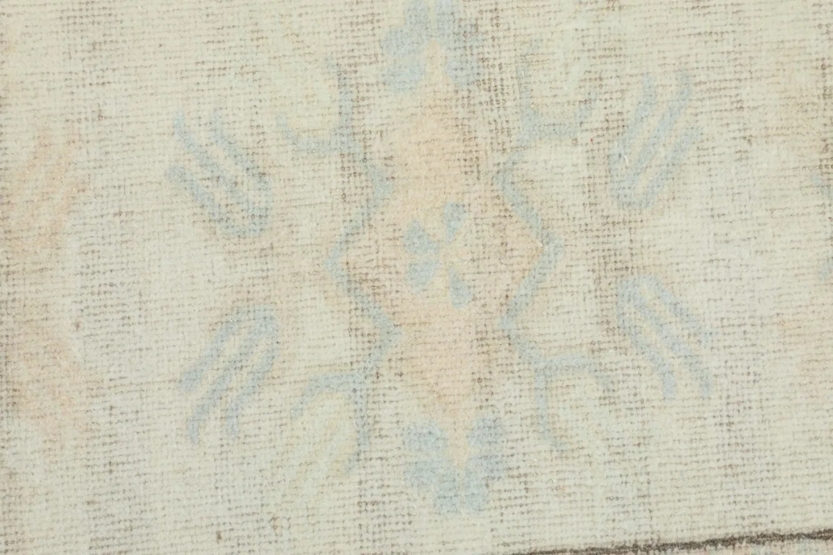 Detailed close-up of the rug's low pile, showing the texture and muted colors