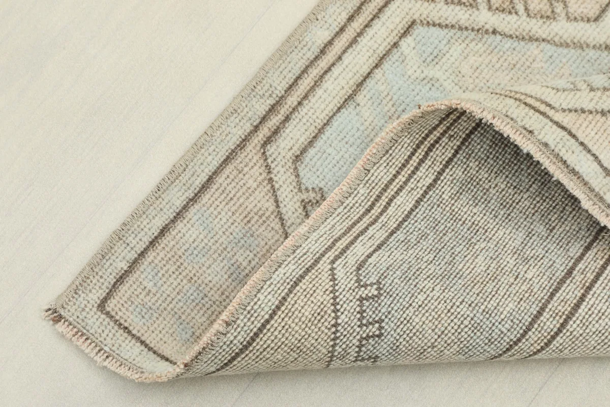 Corner of the rug folded back, showing the thickness and construction of the hand-knotted wool