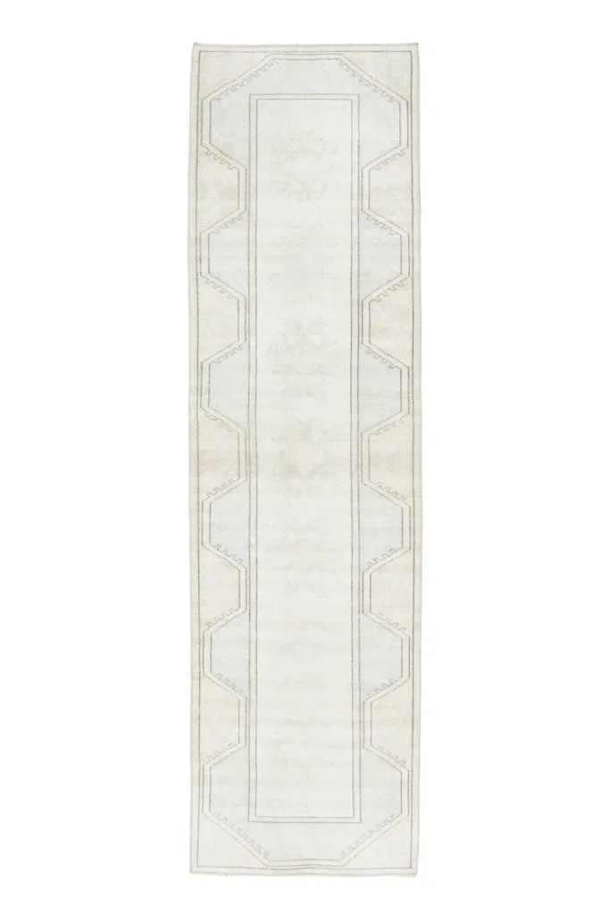 Full overhead view of the ivory and beige vintage runner rug on a white background