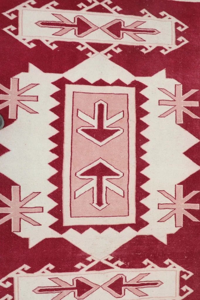 Detailed view of the central medallion with red, ivory, and rose geometric patterns.