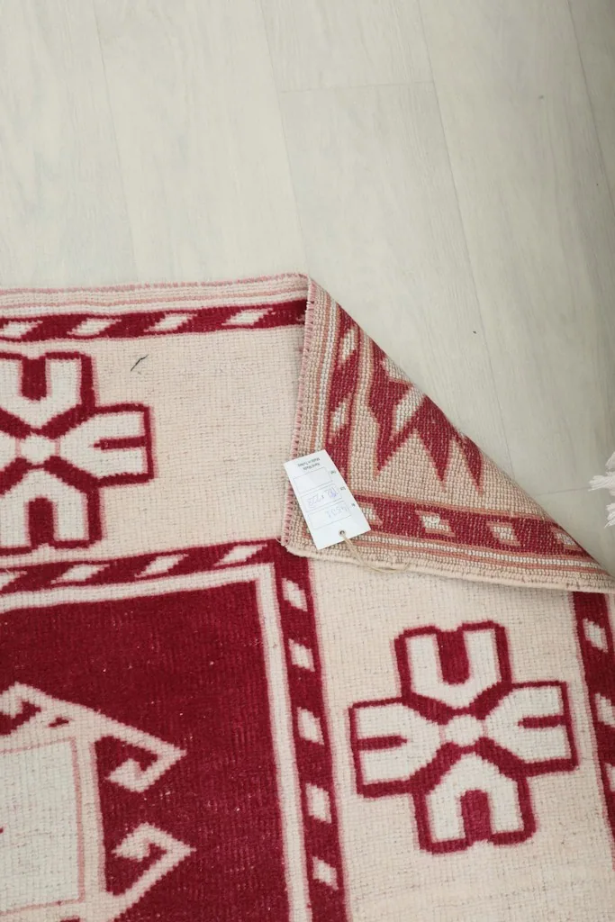View of the back of the rug, showing the tight hand-knotted weave and a product tag.