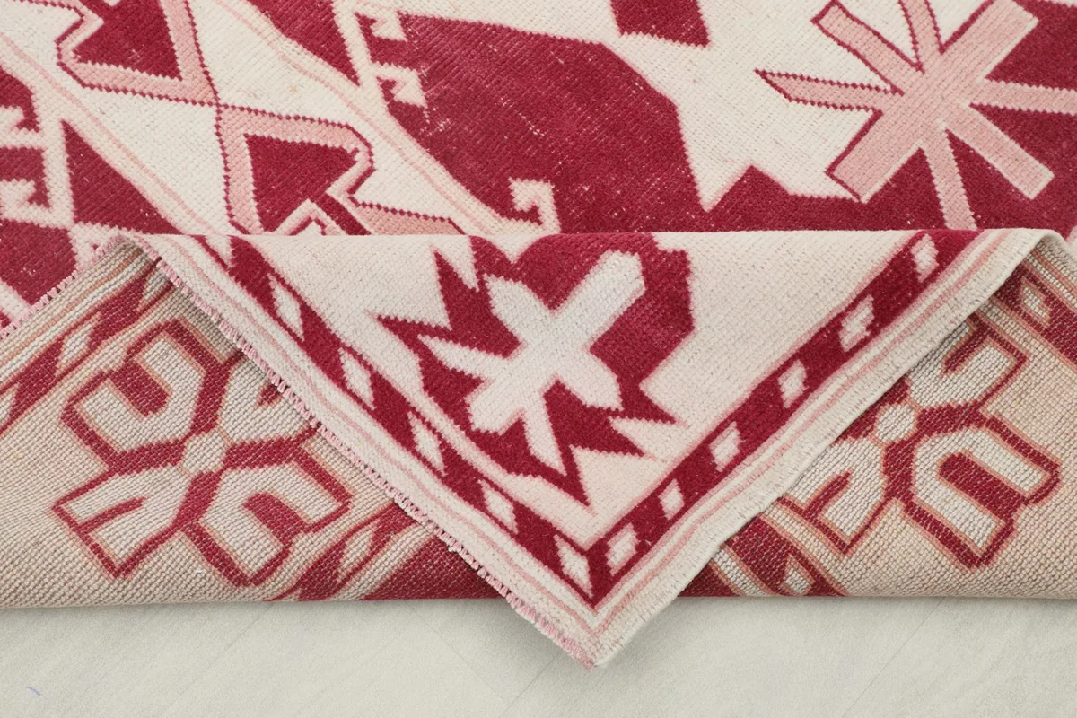 Folded corner of the rug, revealing the thickness of the wool pile and cotton foundation.