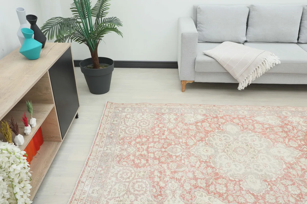 Angle view of the rug in a room, showing its placement relative to a sofa and decor.