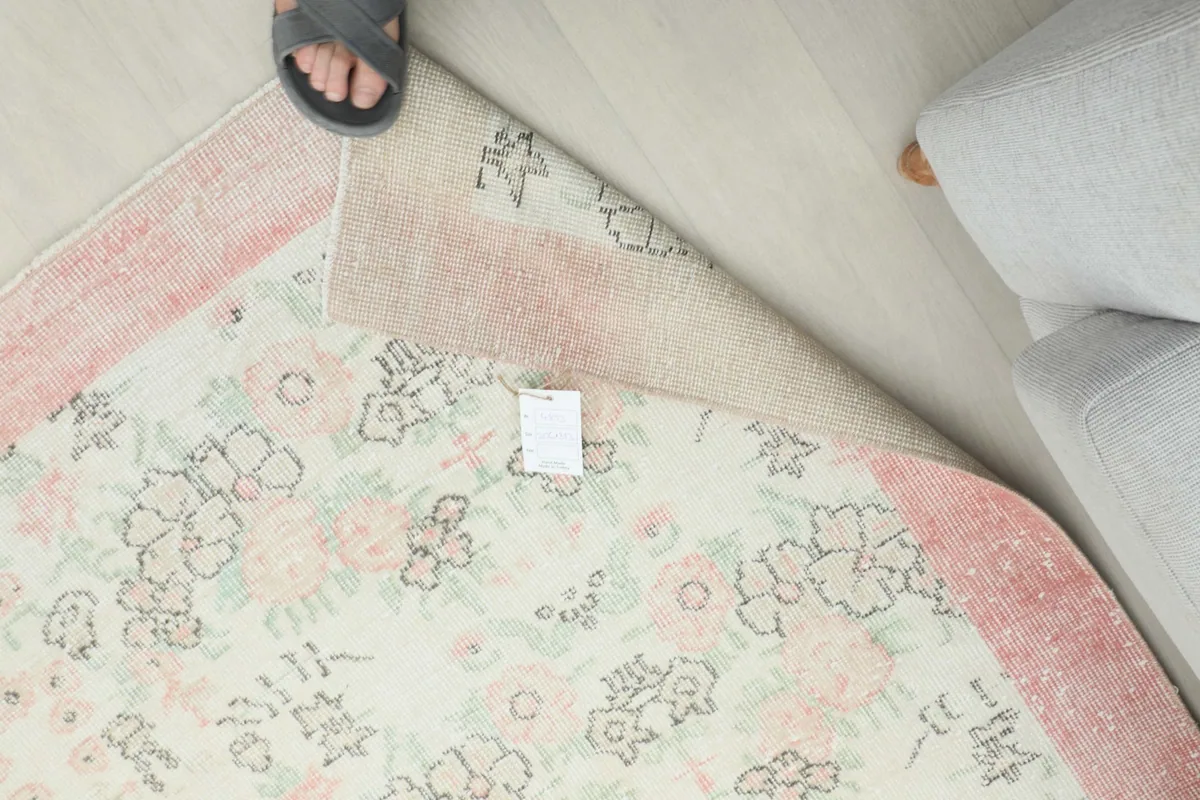 Overhead view showing the rug's tag and the back of the rug where it is gently folded