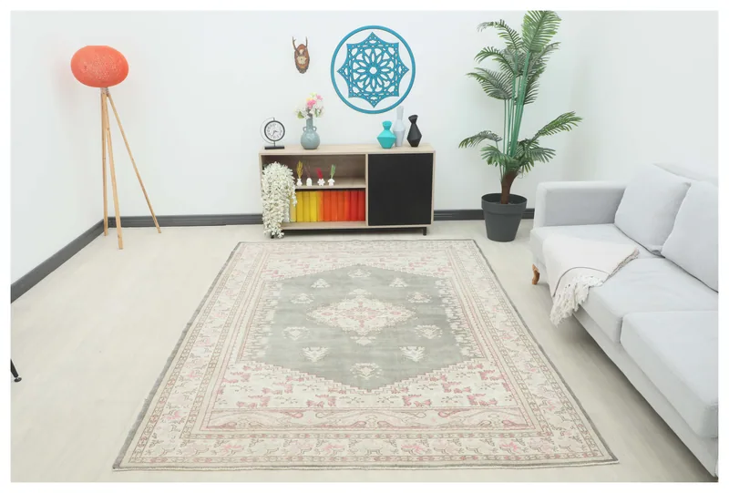 Full overhead view of the gray and pink vintage Anatolian rug on a white background.