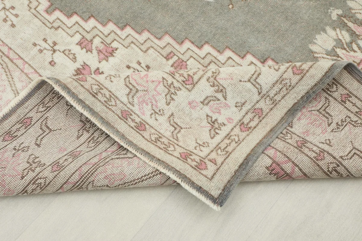 Folded corner of the rug, revealing the back and the hand-knotted wool pile on cotton foundation.