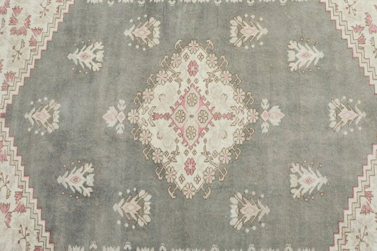 Overhead view showing the central gray field and medallion with pink and beige designs.