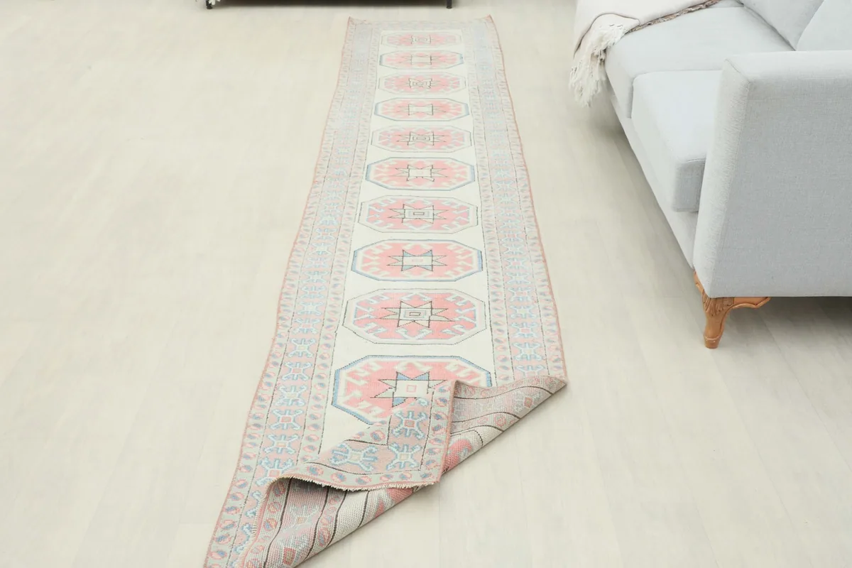 Runner rug partially folded, showing the flexibility and thickness of the wool pile.