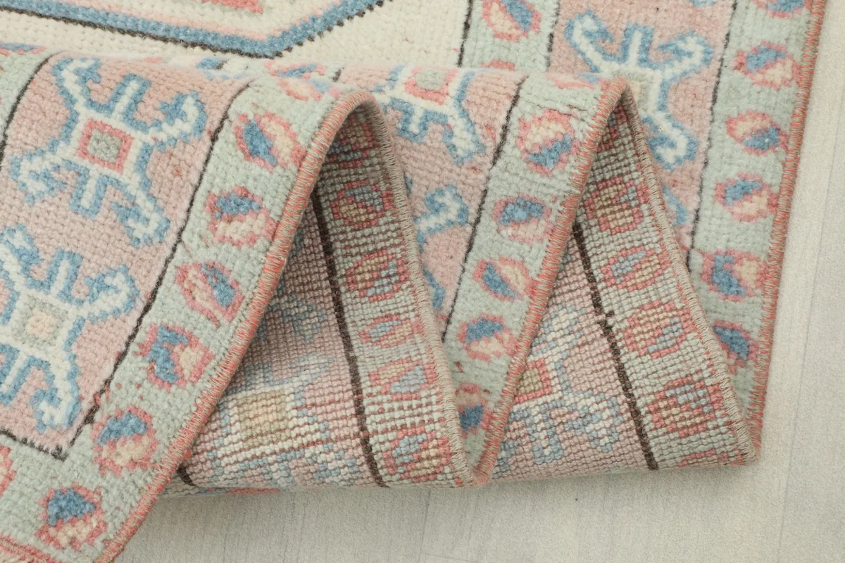 Close-up of the rug's fold, revealing the intricate patterns on both the front and back.