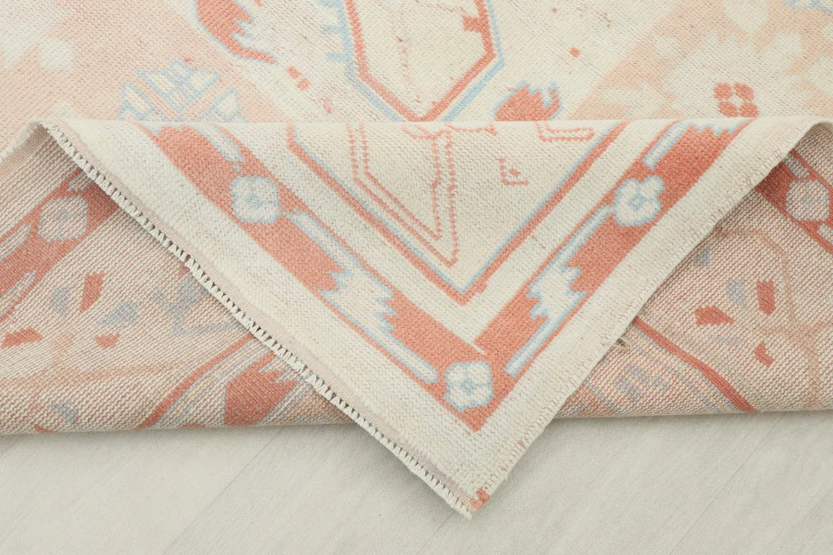 Folded corner of the rug revealing the hand-knotted wool pile and cotton foundation