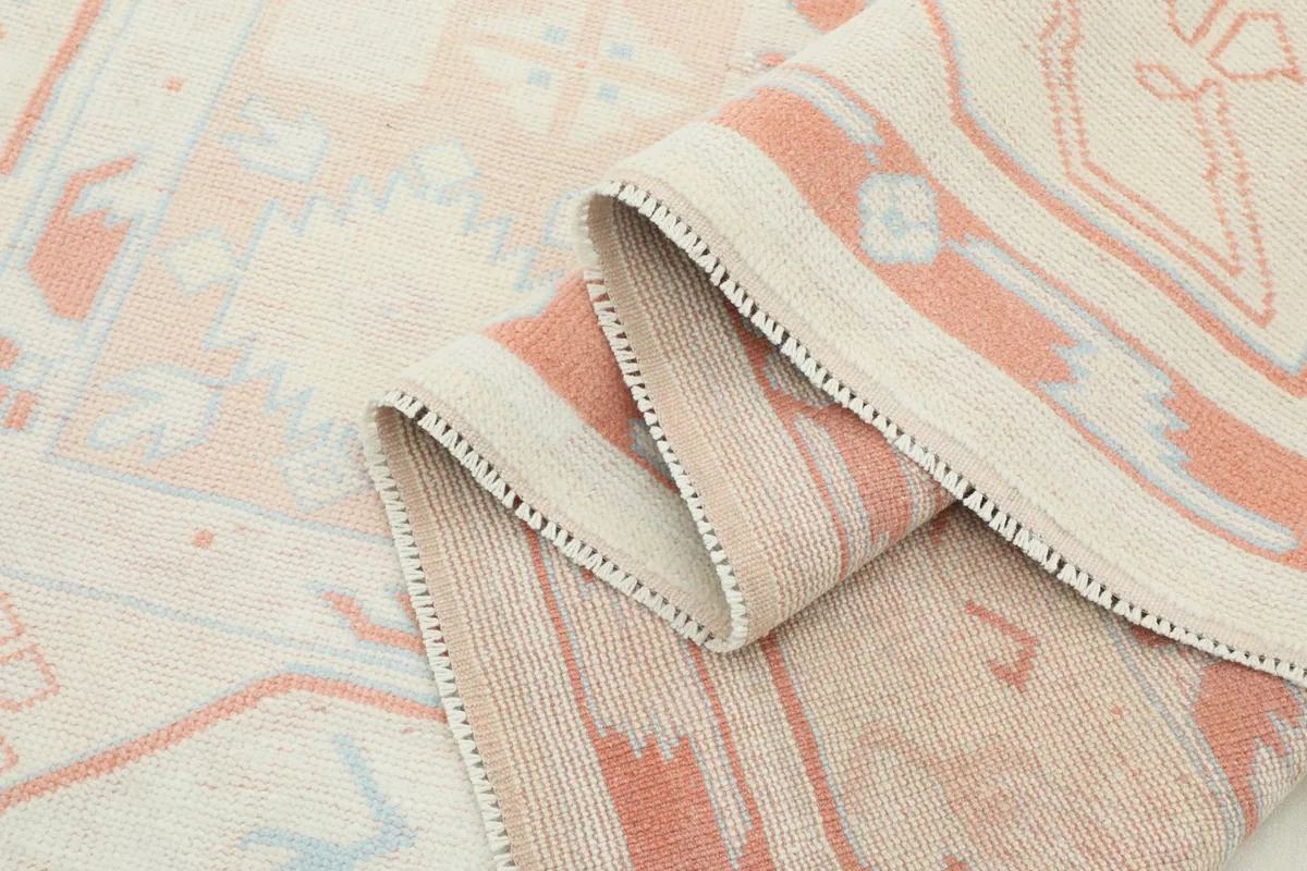 Side view of the rug folded, showing the low pile and texture of the vintage wool