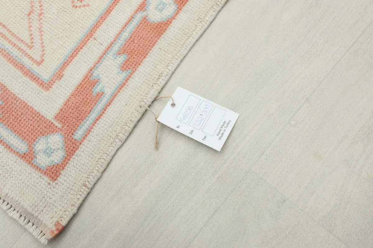 Corner of the rug with the product tag, showing the hand-knotted construction