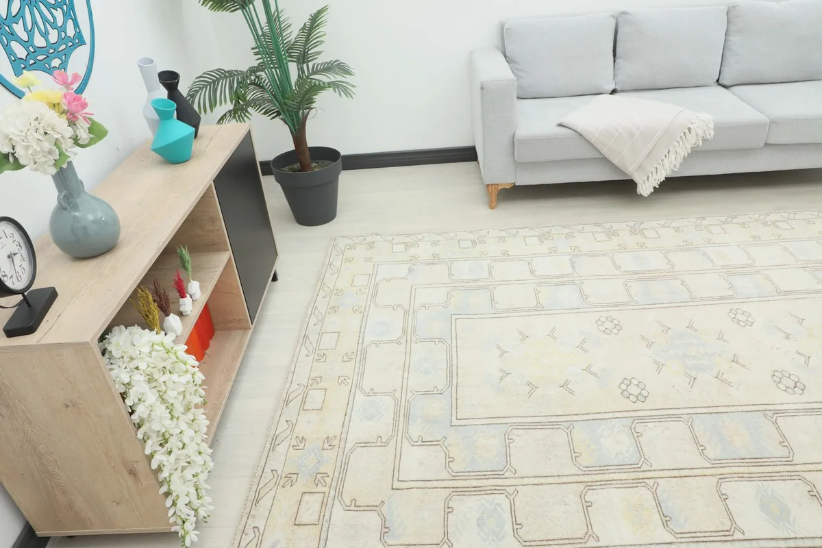 Angle view of the rug in a room, highlighting its placement next to a sofa and cabinet.