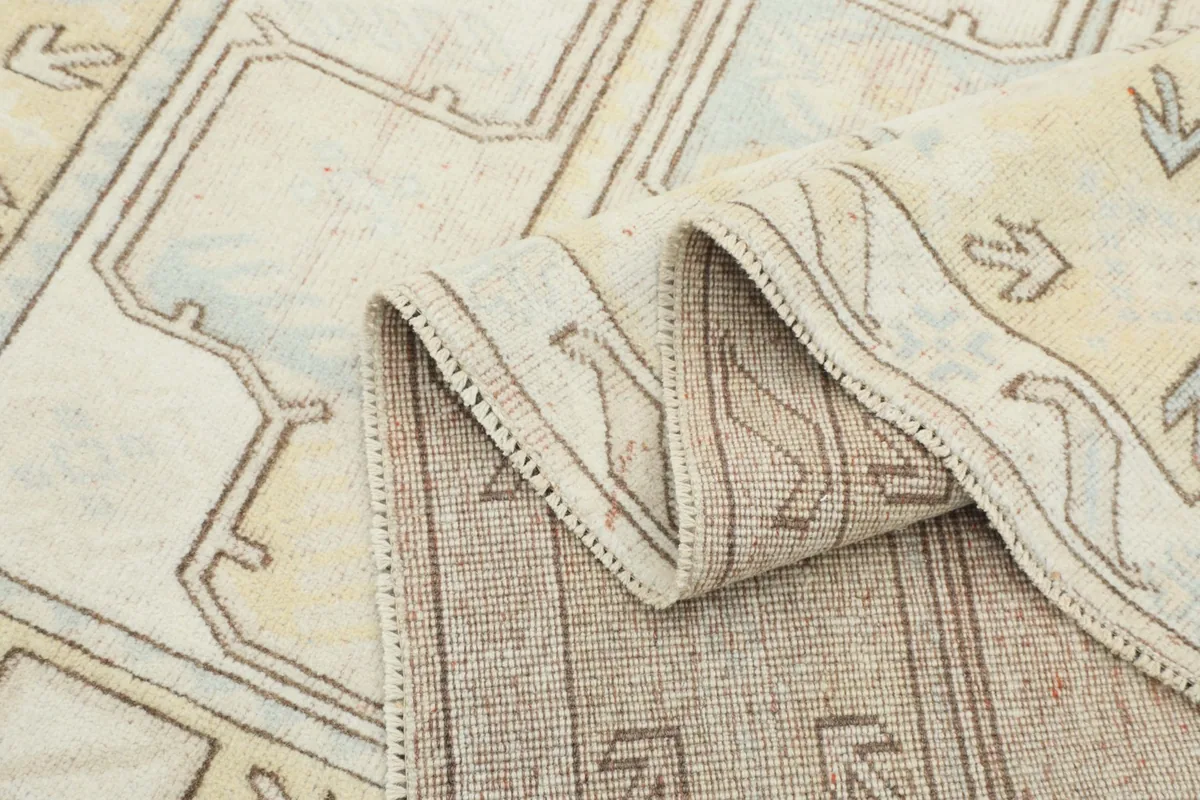 Side view of the rug folded, showing the thickness and the hand-knotted construction.