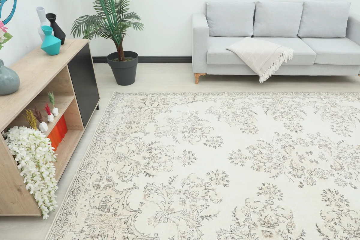 Angle view of the Cream Gray Floral Medallion Rug in a room with a sofa