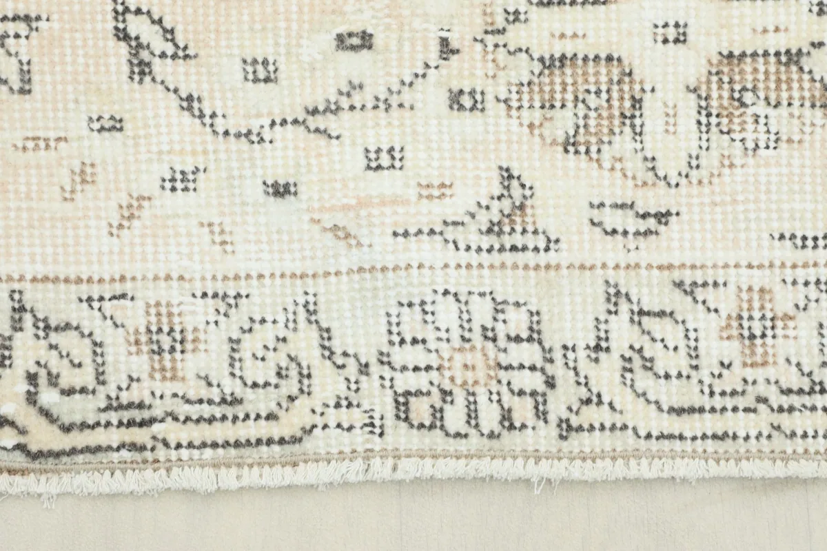 Close-up view of the rug's border and fringe showing the hand-knotted texture