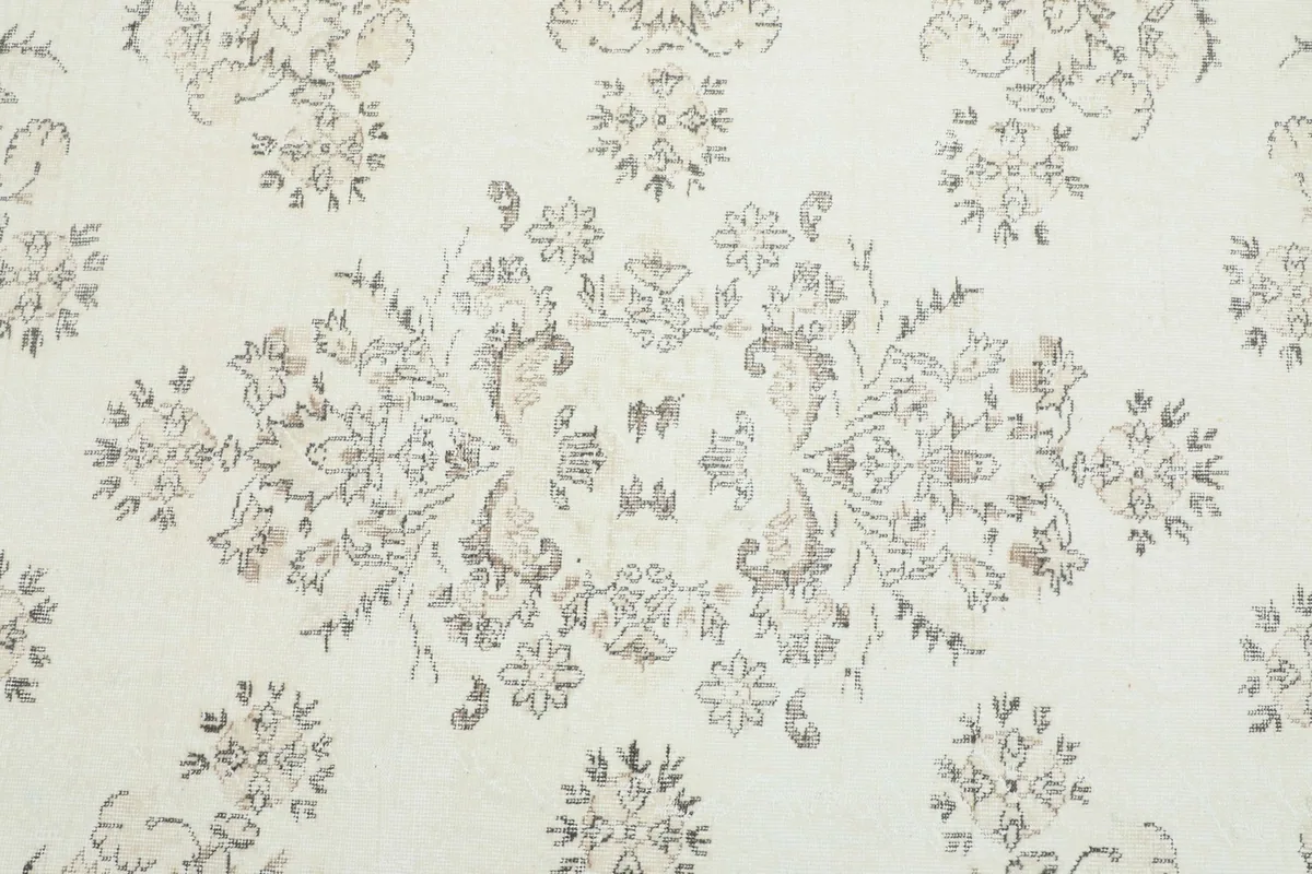 Detailed view of the central floral medallion motif in gray and tan
