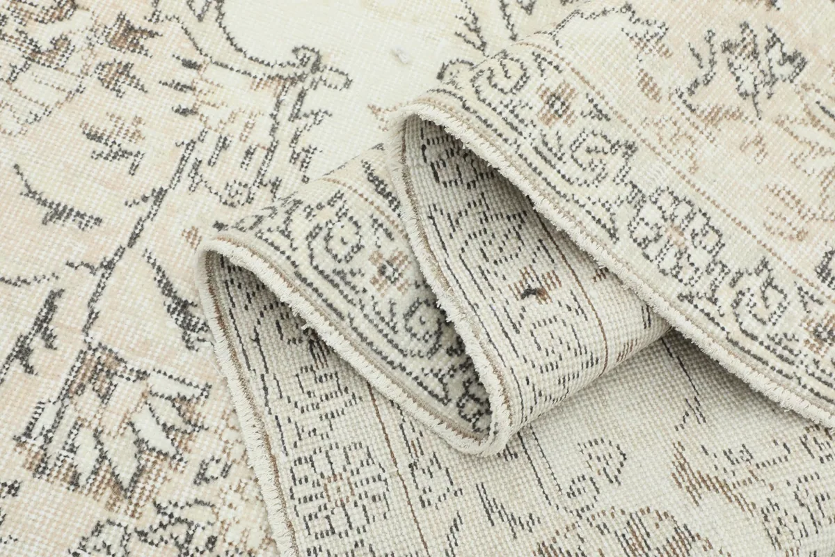 Rolled section of the rug, highlighting the thickness and border design