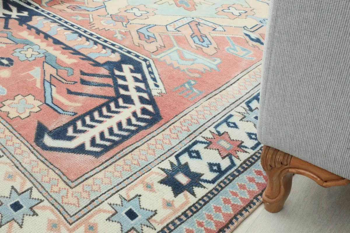 Rug shown in a room setting with a chair leg visible, offering perspective on its size and placement.