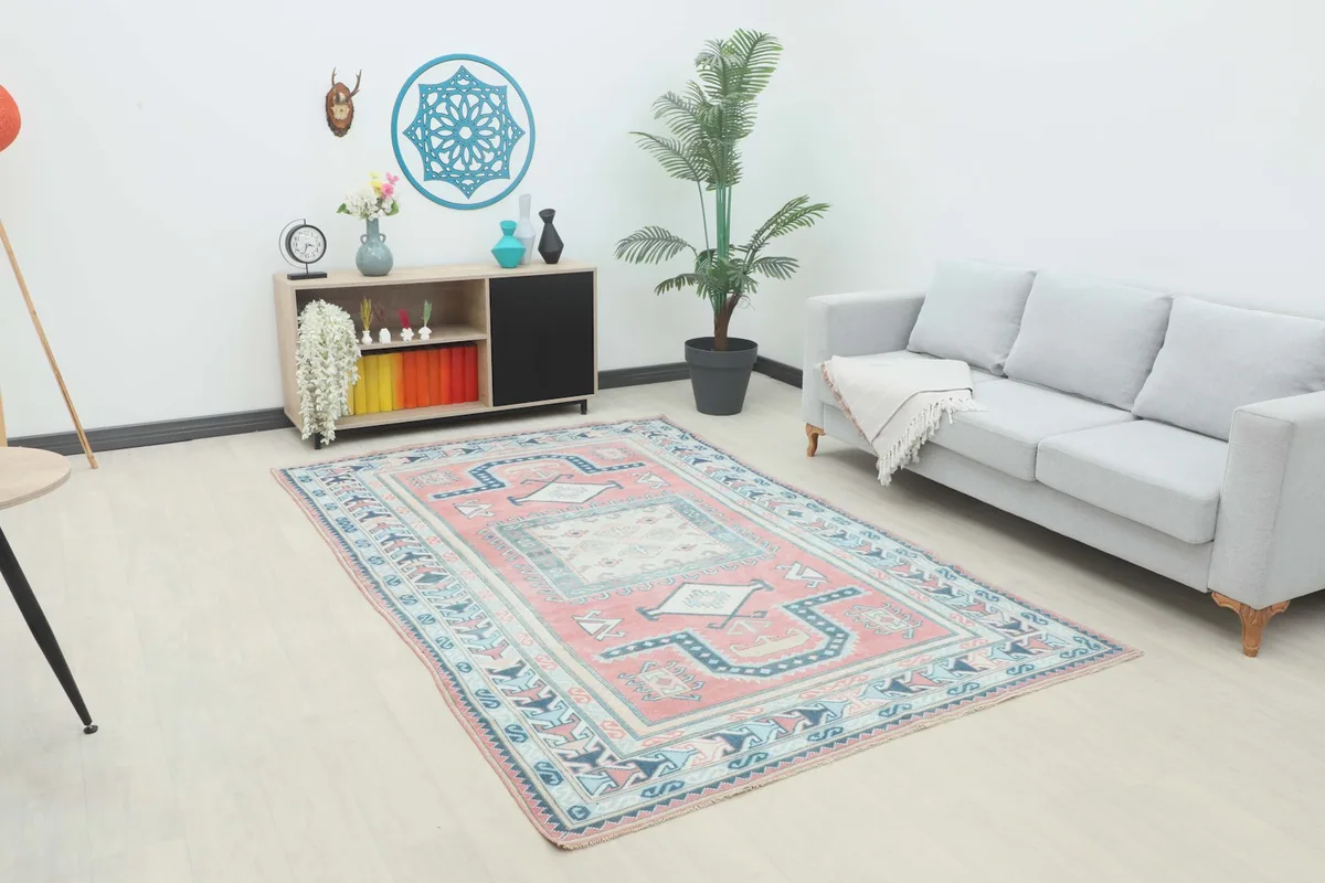 Vintage Anatolian rug displayed in a bright living room setting with a gray sofa.