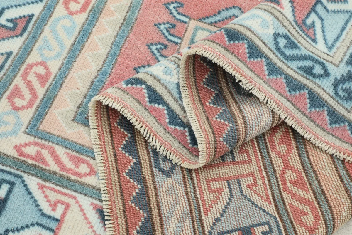 Close-up of the low wool pile and the texture of the hand-knotted vintage rug.